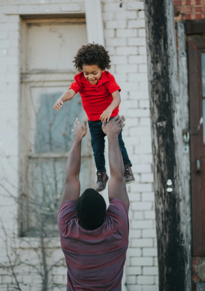 Man Playfully Throwing Child In The Air Family Dependants Care Workers Ban Thumbnail