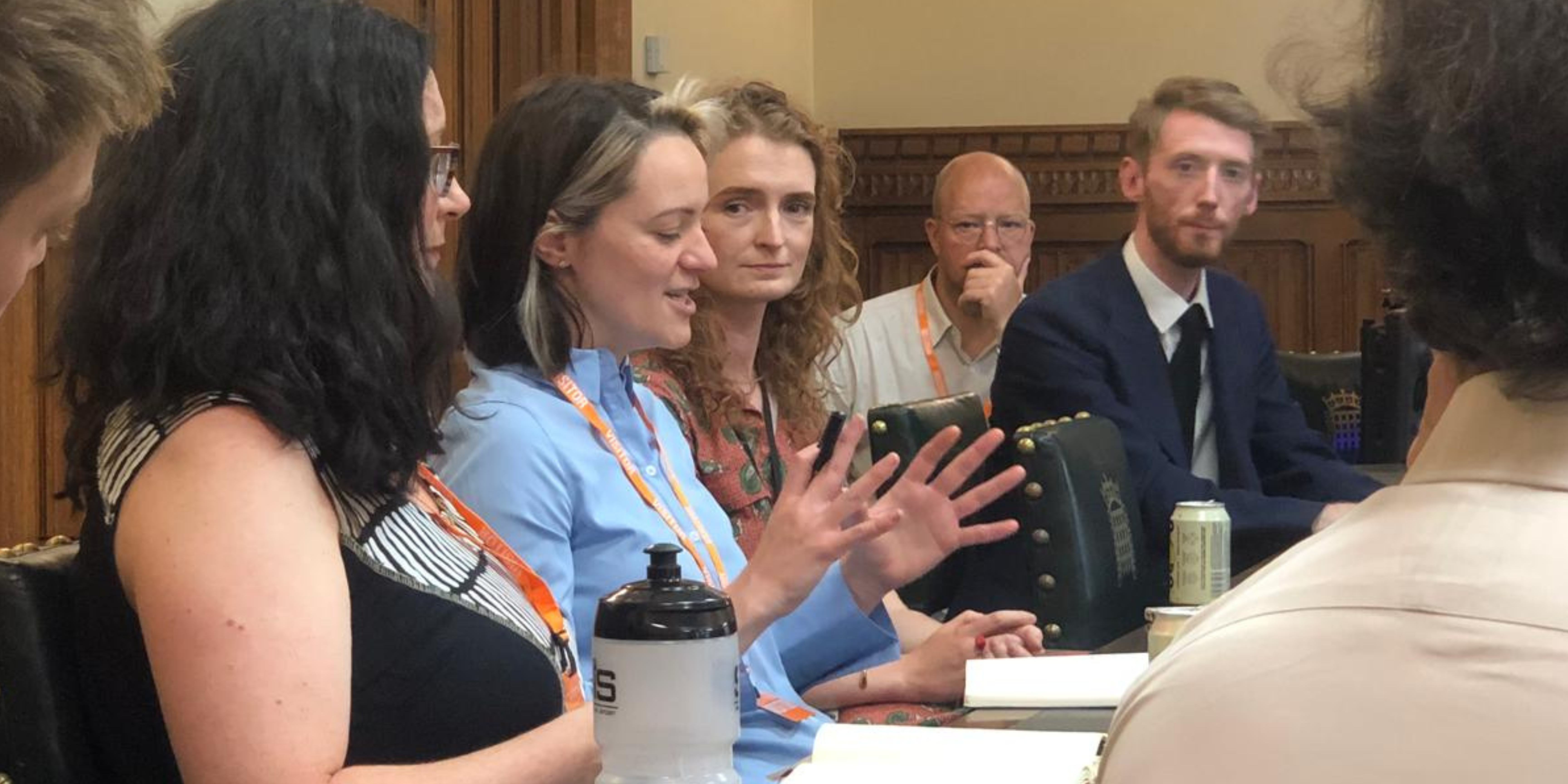 A woman gestures with her hands to explain labour exploitation to a panel of people