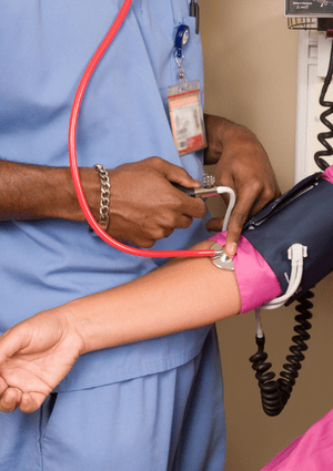 Male Care Worker Takes The Pulse Of Woman Risk For Health And Care Workers Thumbnail